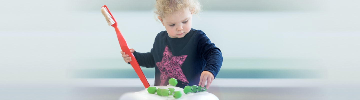 Kleinkind mit riesiger Zahnbürste in der Hand, Kieferorthopädie an der Parkinsel, Ludwigshafen